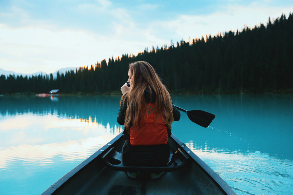 woman canoeing on a lake by the forest
